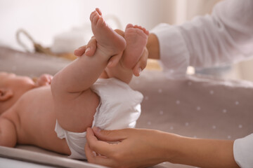 Mother changing her baby's diaper on table, closeup