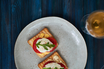 Tasty home breakfast of square toast with sliced fresh tomato and egg benedict with urugula.