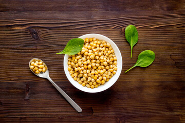 Raw chickpeas in bowl on wooden kitchen table top view