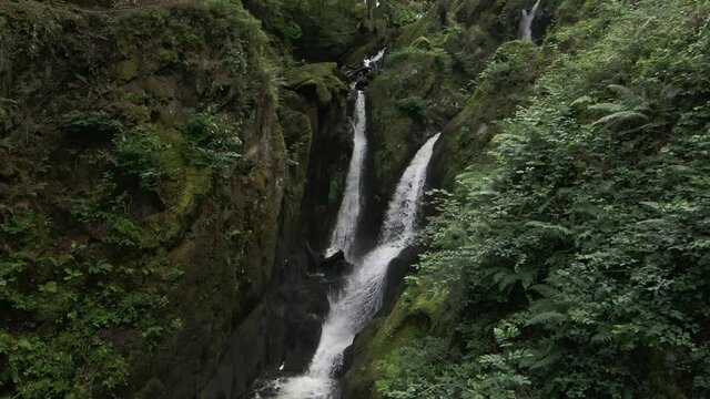 Slow motion drone footage of Stock Ghyll Force waterfall at Ambleside in the Lake District, Cumbria, England, UK