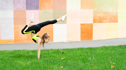 Fitness sport young girl in sportswear doing yoga fitness exercise on a wall background. Sporty...
