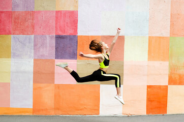 Fitness sport young girl in sportswear doing yoga fitness exercise on a wall background. Sporty gymnast child preteen running training outdoor - 364742513