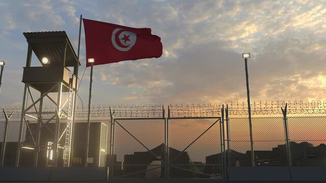National flag of Tunisia above military base at sunset