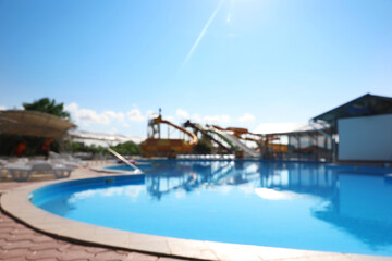Fototapeta na wymiar Blurred view of water park with swimming pool. Summer vacation