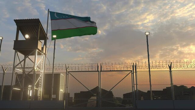Waving flag of Uzbekistan above military base in the evening