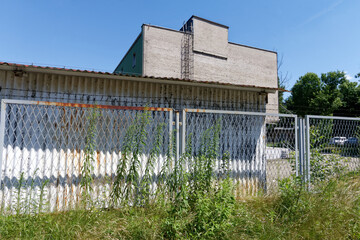 Magazyn przemysłowy z cegły za ogrodzeniem  © Miroslaw