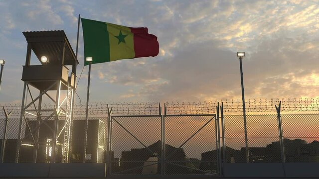 National flag of Senegal above military base at sunset