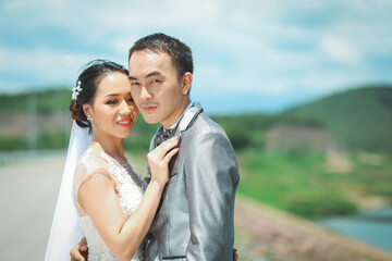 Portrait of Asian bride and groom with beautiful landscape of dam and mountain