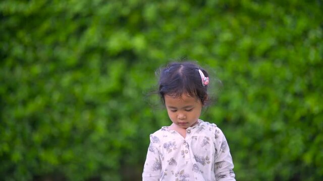 Cute litte girl walking in garden.