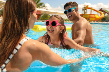 Obraz premium Happy family in swimming pool. Summer vacation