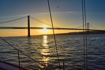 Fototapeta na wymiar View of sunset over Rio Tejo and ponte de 25 abril from a boat, near lisbon, portugal