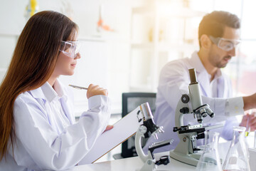 Attractive happiness scientist lab technician assistant analyzing sample in test tube and using...