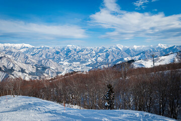 Fototapeta na wymiar view from top mountain, white snow and beautiful landscape during winter season in Japan against blue sky background