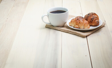 Croissant and coffee  isolated on wood table