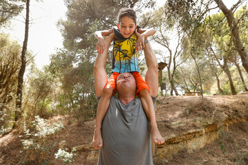 papà bianco gioca con il proprio figlio di origine Italo- brasiliana tirandolo su verso l'alto in...