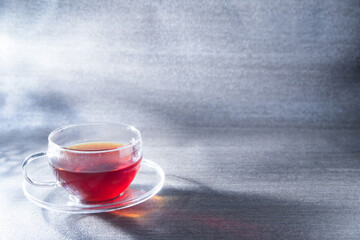 光が差し込む透明グラスに入った紅茶。癒し・休憩・カフェ・ティータイム