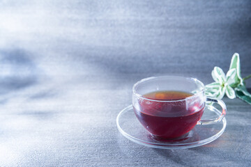 光が差し込む透明グラスに入った紅茶。癒し・休憩・カフェ・ティータイム