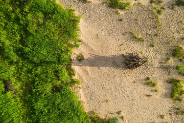 Midsummer celebration preparation. Drone view of woodpile of dry branches on the sand. Green grass.