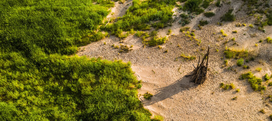 Midsummer celebration preparation. Drone view of woodpile of dry branches on the sand. Green grass.