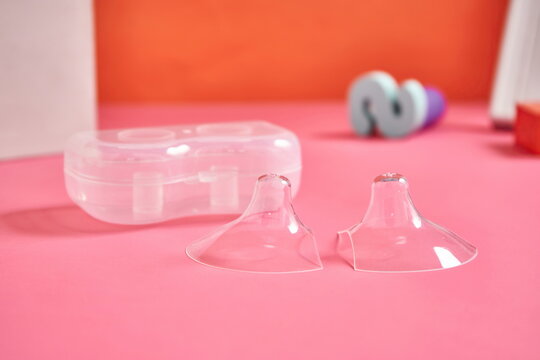 Two nipple covers on a pink background