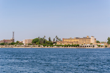 Obraz premium Luxor, Egypt: Panorama of river Nile in Luxor city, view from a boat. Residental buildings and sailboats.