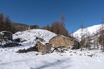 Fototapeta na wymiar Ruins of stone buildings in winter mountains