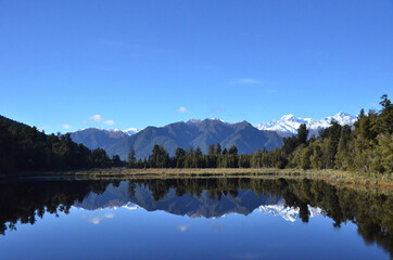 Fototapeta premium Lake Matheson, near the Fox Glacier in South Westland, New Zealand, is famous for its reflected views of Aoraki/Mount Cook and Mount Tasman.