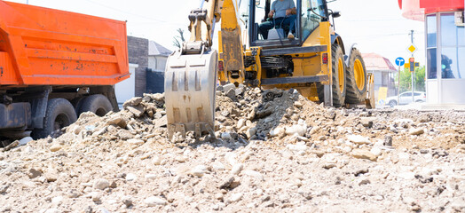 Excavator bucket digs the ground