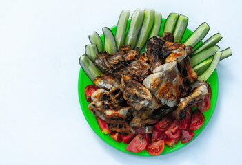 Fried chicken, tomatoes and cucumbers on a white background