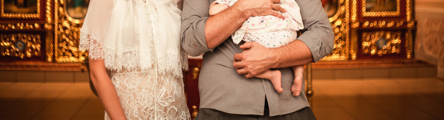 Father's day. A man holds a baby in his arms and stands next to his mother. Close-up photo. Family, three people
