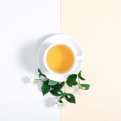 Jasmine flowers and cup of herbal tea on white background. Jasmine tea concept. Flat lay, top view, copy space