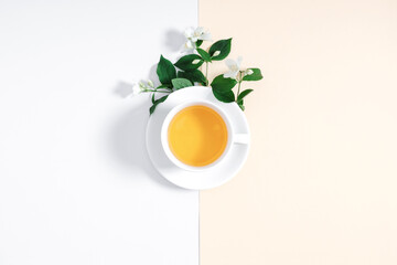Jasmine flowers and cup of herbal tea on white background. Jasmine tea concept. Flat lay, top view, copy space