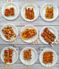 The grilled pork on a plate lined up with chili peppers that look delicious.