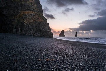 Reynisfjara, a volcanic black sand beach, in the background the rocks of Reynisdrangar, in Vik,...