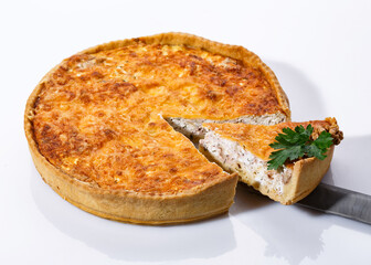 Taking of delicious mushroom pie with a kitchen spatula. Fragrant vegetable pie on white background.