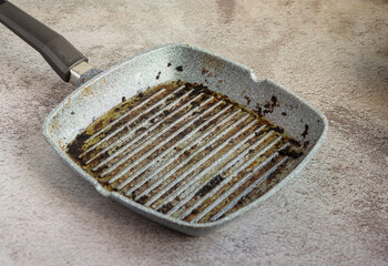 Dirty grill pan.Frying pan with burnt fat after frying meat.