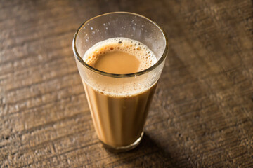 A glass of tea kept on a wodden table