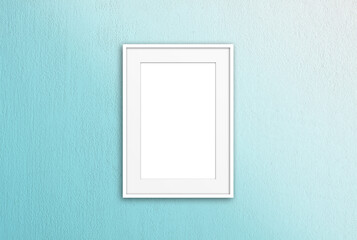 White photo frame mock up isolated on light green painted  wall	