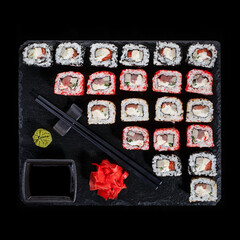 Originally put a set of sushi on a black board. With chopsticks, ginger, wasabi and soy sauce.