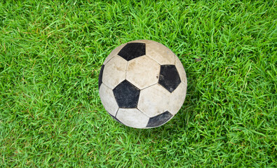 Old football on green artificial feild. 