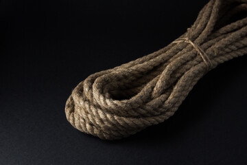 Jute rope lies on a black background. A bunch of jute rope.