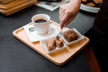 black coffee and chocolate brownie put on wooden plate