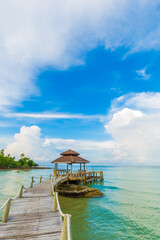 Wooden bridge to the sea beach with wooden hut blue sky