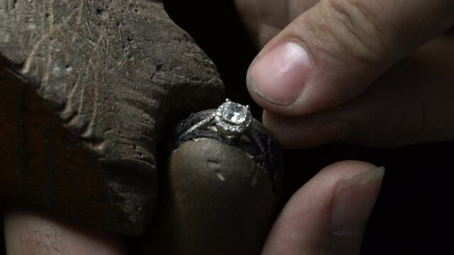 diamond ring making. jeweler putting ring on ring close up. handmade diamond ring production. Craftsman makind diamond .