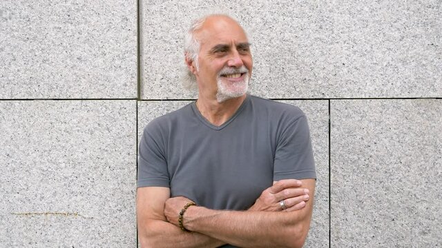 Slow motion shot of smiling senior athletic man with arms crossed