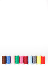 Colorful cotton craft sewing threads multicolored in a row isolated on a white background.