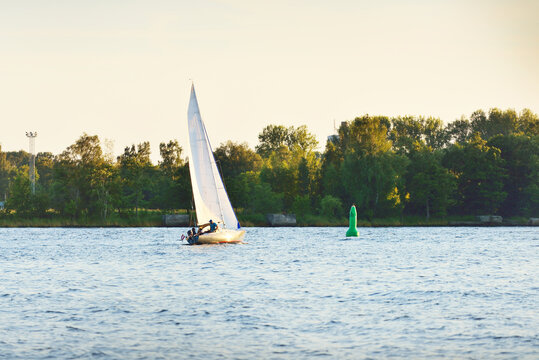 Sloop rigged yacht sailing in Riga bay at sunset. Baltic sea, Latvia. Amatour racing, sport, recreation, leisure activity, teamwork concepts