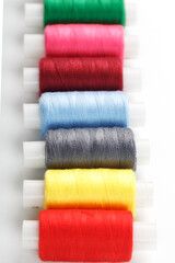 Fototapeta na wymiar Colorful cotton craft sewing threads multicolored in a row isolated on a white background.