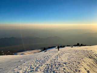 Mountain Elbrus. Climbers with backpacks and trekking poles walk along a snowy path.