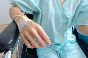 Close up of saline drip in patient's hand in hospital admission,  hand had injection plug for injecting fluid drug seat on a wheelchair,Healthcare and medically concept.